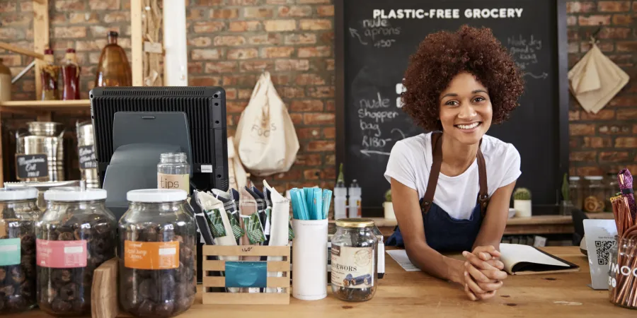 Smiling small business owner behind her shop counter